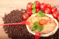 Closeup of pizza with coffee beans,two red forks, tomatoes, cheese and basil on wooden background