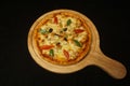 Closeup of a pizzetta stuffed with peppers and olive on a wooden tray