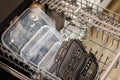 closeup of plastic containers in a dishwasher, in a kitchen