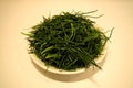 Closeup of a plate of agretti, or salsola soda, raw ready to be cooked