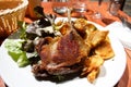 Closeup of a plate of confit de canard in a restaurant Royalty Free Stock Photo