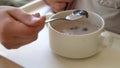 Closeup plate flakes with milk mom feed young baby in white feeding up high chair, kid is trying to eat himself, child Royalty Free Stock Photo