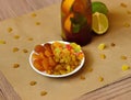 Closeup of a plate with raisins, dried apricots, a cocktail, juicy slices of lime on a blurred light background. Royalty Free Stock Photo