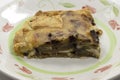 Closeup of a plate with a slice of homemade aubergine pie with cheese