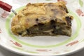 Closeup of a plate with a slice of homemade aubergine pie with cheese