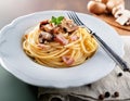 Closeup plate of spaghetti ham with Cabonara cream source with fork on table background Royalty Free Stock Photo