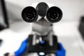 Closeup point of view of laboratory assistant looking through microscope lens