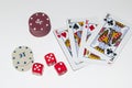 Closeup of poker chips, playing cards, and dice on the white surface Royalty Free Stock Photo