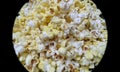 Closeup of popcorns with melted butter isolated from black round vignettes frame, food photography, snacks background