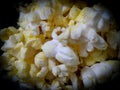 Closeup of popcorns with melted butter isolated from black round vignettes frame, food photography, snacks background