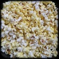Closeup of popcorns with melted butter isolated from black round vignettes frame, food photography, snacks background