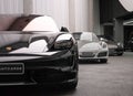 Closeup of a Porsche Taycan in front of a Porsche 911 Targa 4s and a 911 Turbo