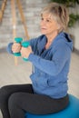 Closeup portrait active senior woman doing dumbbell exercises