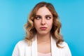 Closeup portrait of adorable funny woman looking cross-eyed with awkward silly dumb face. blue background