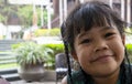 Closeup portrait of adorable little Asian girl smiling happily wearing green dress while enjoying traveling with family during