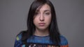 Closeup portrait of adult caucasian brunette female face looking at camera with background isolated on gray