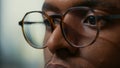 Closeup portrait of african american database developer with glasses working focused looking at computer screen
