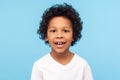 Closeup portrait of amazing cheerful little boy with curly hairdo in white T-shirt looking at camera with happy carefree smile Royalty Free Stock Photo