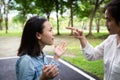 Closeup portrait angry adult mother quarreling,arguing with young daughter in outdoor park,parent and asian child girl shouting at
