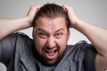 Closeup portrait of angry, frustrated man, pulling his hair out. Negative human emotions and facial expressions Royalty Free Stock Photo