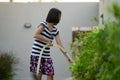 Closeup Portrait of Asian little girl watering the colourful blossom flowers by watering can