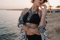 Closeup portrait of attractive young girl taking off stylish sunglasses, on sunset, on beach with sensual look. Wearing Royalty Free Stock Photo