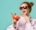 Closeup portrait of Bartender woman with strawberry margarita cocktail in hand in red sunglasses Royalty Free Stock Photo