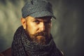 Closeup portrait of bearded man in leather jacket, woolen scarf and cap. Casual winter clothes. Handsome stylish man Royalty Free Stock Photo