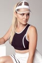 Closeup portrait of beautiful athletic young woman with makeup, blonde hair in fashionable teniss sportwear and white clear cap,