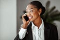Closeup portrait of black businesswoman talking on phone in office, enjoying business conversation, having pleasant call