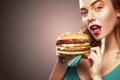 Closeup portrait. Beautiful blond young woman having fun eating big burger. Advertisment for cafe. Royalty Free Stock Photo