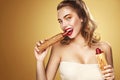 Closeup portrait. Beautiful blond young woman having fun eating french hot dog on Oktoberfest holiday. Royalty Free Stock Photo