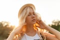 Closeup portrait of a beautiful blonde woman with curly blonde hair and straw hat. Royalty Free Stock Photo