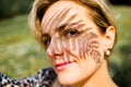 Closeup portrait of beautiful Caucasian middle age woman holding green leaf in summer park Royalty Free Stock Photo