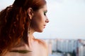 Closeup portrait of beautiful fashion model over beige background, pretty redhead woman with stylish green makeup and body art Royalty Free Stock Photo