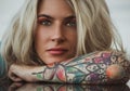 Closeup portrait of. Beautiful girl put her head in her arms with tattoos. expectation. Royalty Free Stock Photo