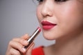 Closeup portrait of beautiful girl putting on red lipstick Royalty Free Stock Photo