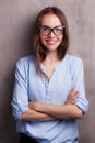 Portrait of beautiful happy young woman wearing glasses near grey grunge wall Royalty Free Stock Photo