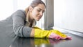 Closeup portrait of beautiful smiling housewife washing kitchen countertop Royalty Free Stock Photo