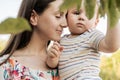 Closeup portrait of beautiful mother hold and hug her baby son with love and care at nature Royalty Free Stock Photo