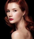 Closeup portrait of a beautiful red-haired girl half-turned over