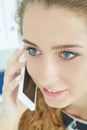 Closeup portrait of beautiful smiling young girl talking on the mobile phone in the office. Royalty Free Stock Photo