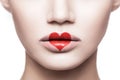 Closeup portrait of beautiful woman face with makeup and red heart shape on her lips. valentines day and beauty love and care Royalty Free Stock Photo