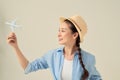 Closeup portrait of beautiful woman in straw hat holding airplane model in hand, dreaming about holidays Royalty Free Stock Photo