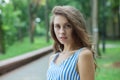 Closeup portrait of beautiful woman in summer dress posing in green park enjoying weekend. Playful and beautiful caucasian girl on Royalty Free Stock Photo