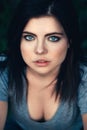 Closeup portrait of beautiful young Caucasian woman with black hair, blue eyes, looking in camera Royalty Free Stock Photo