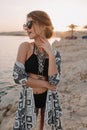 Closeup portrait of beautiful young girl on beach, enjoying sunset, sensualy looking to side. Wearing trendy black Royalty Free Stock Photo