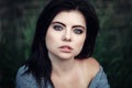 Closeup portrait of beautiful young Caucasian woman with red black hair, blue eyes, looking in camera, outdoors on sunset, su Royalty Free Stock Photo