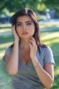 Closeup portrait of beautiful young Caucasian woman with red black hair, blue eyes, looking in camera, outdoors on sunset Royalty Free Stock Photo