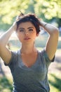 Closeup portrait of beautiful young Caucasian woman with red black hair, blue eyes, looking in camera, outdoors on sunset Royalty Free Stock Photo